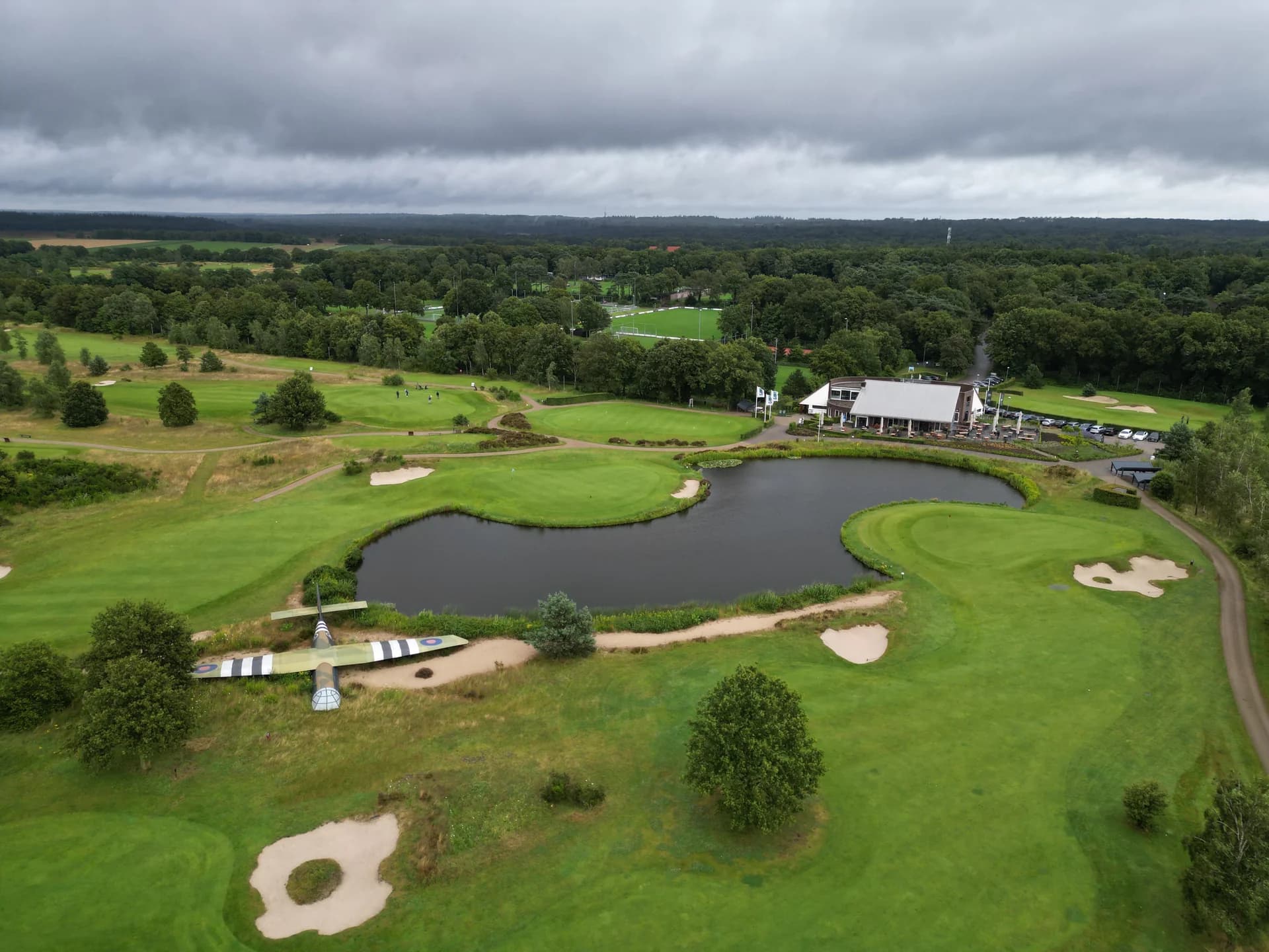 Luchtfoto van de golfbaan met waterpartijen en clubgebouw tijdens het 4PS-golfevent.