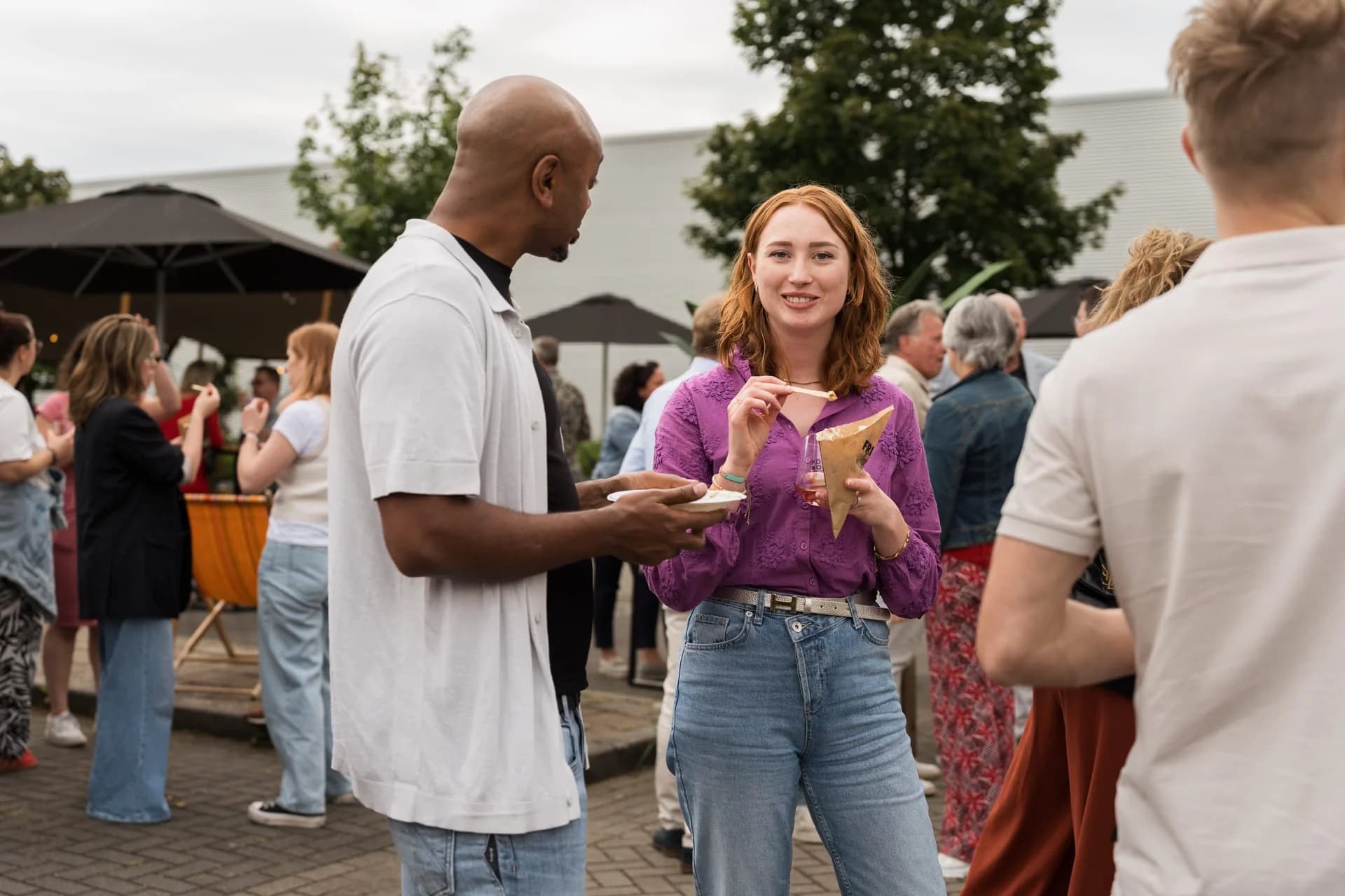 Gasten praten met elkaar tijdens het zomerfeest van 4PS in 2024.