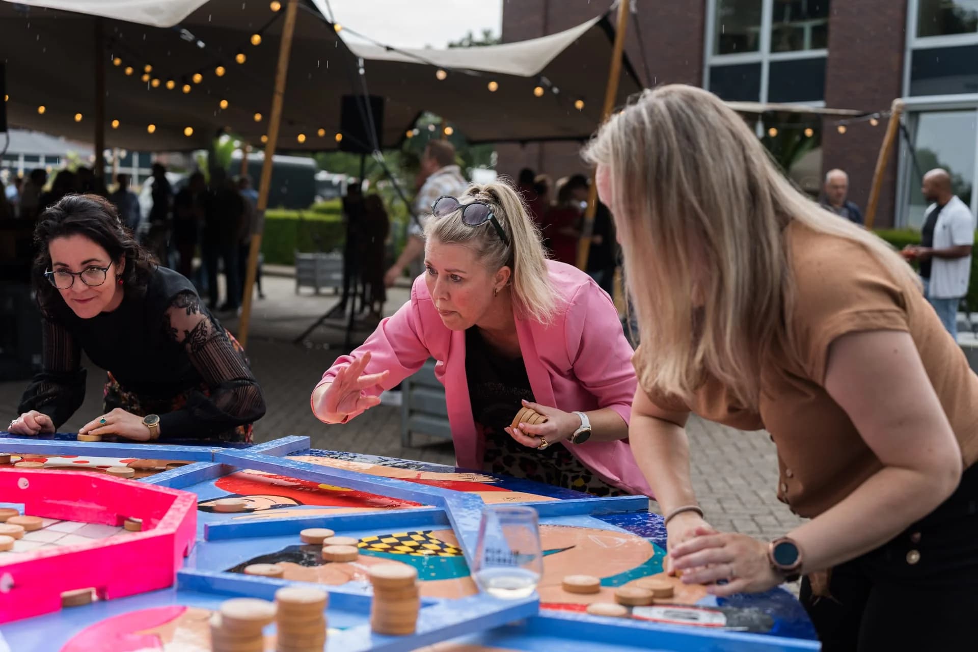 Gasten spelen een kleurrijk tafelspel tijdens het zomerfeest van 4PS.