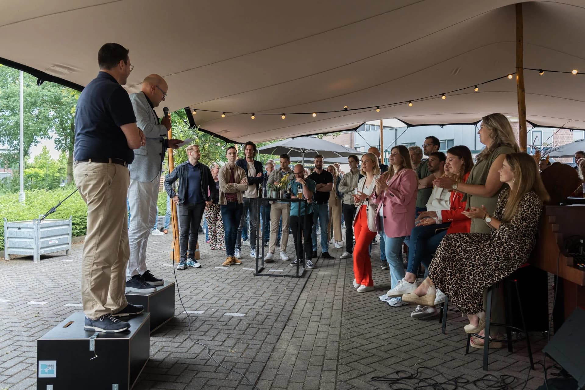 Spreker houdt een toespraak voor gasten in de feesttent van 4PS.