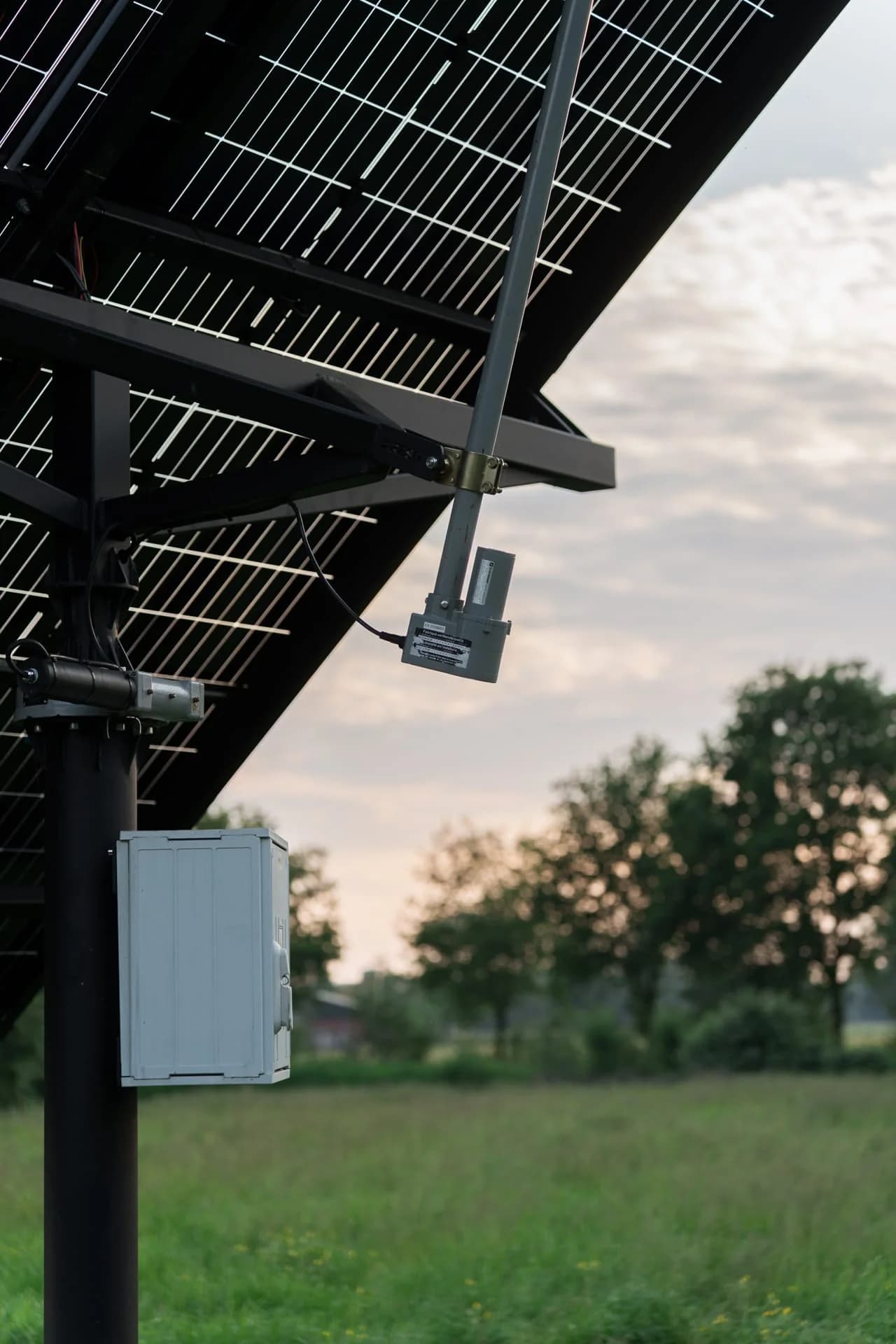 Onderzijde en draaimechanisme van een solar tracker in een weiland.