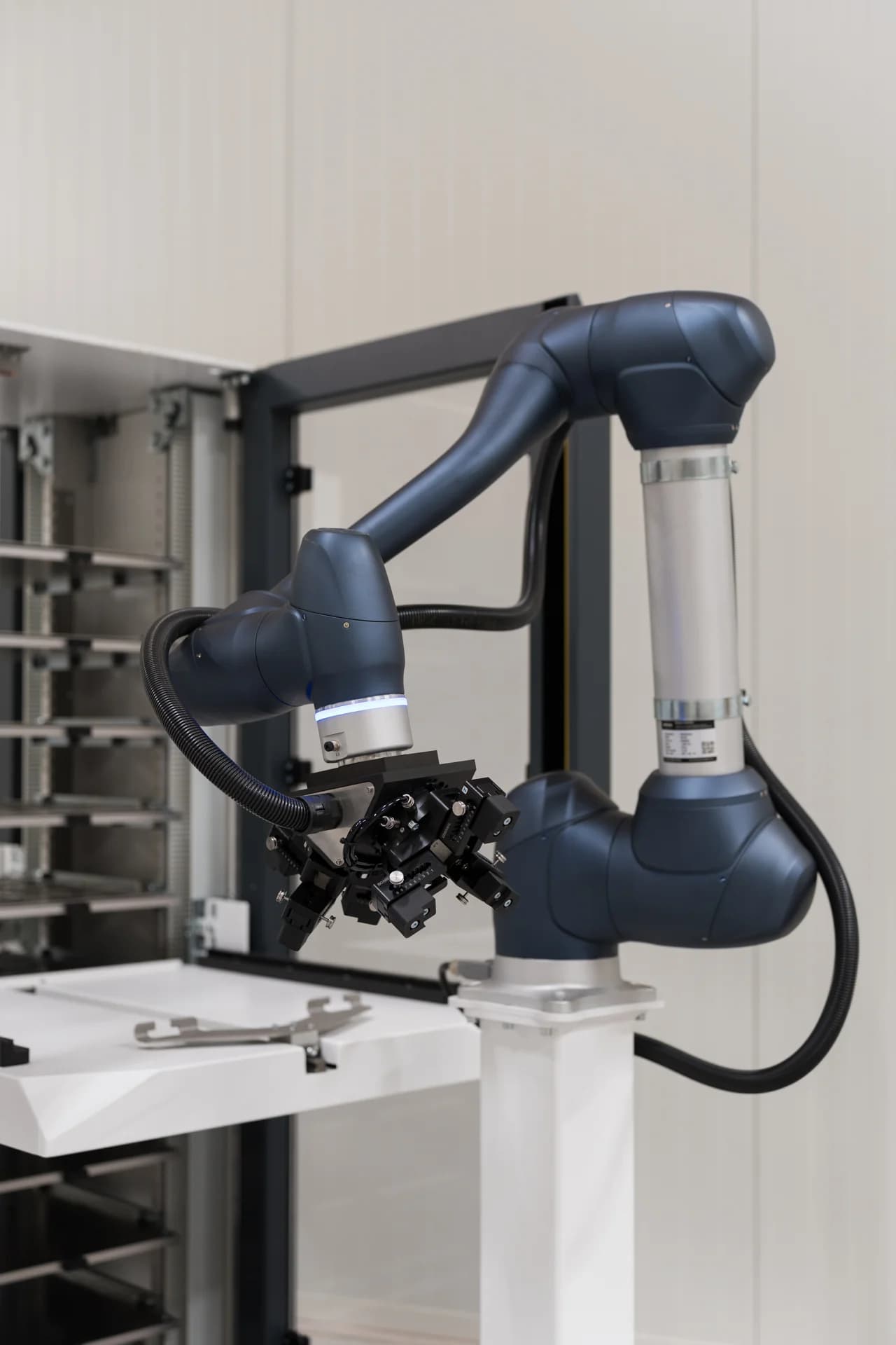 Robotarm met grijper naast het platenmagazijn van de MetaLoader.