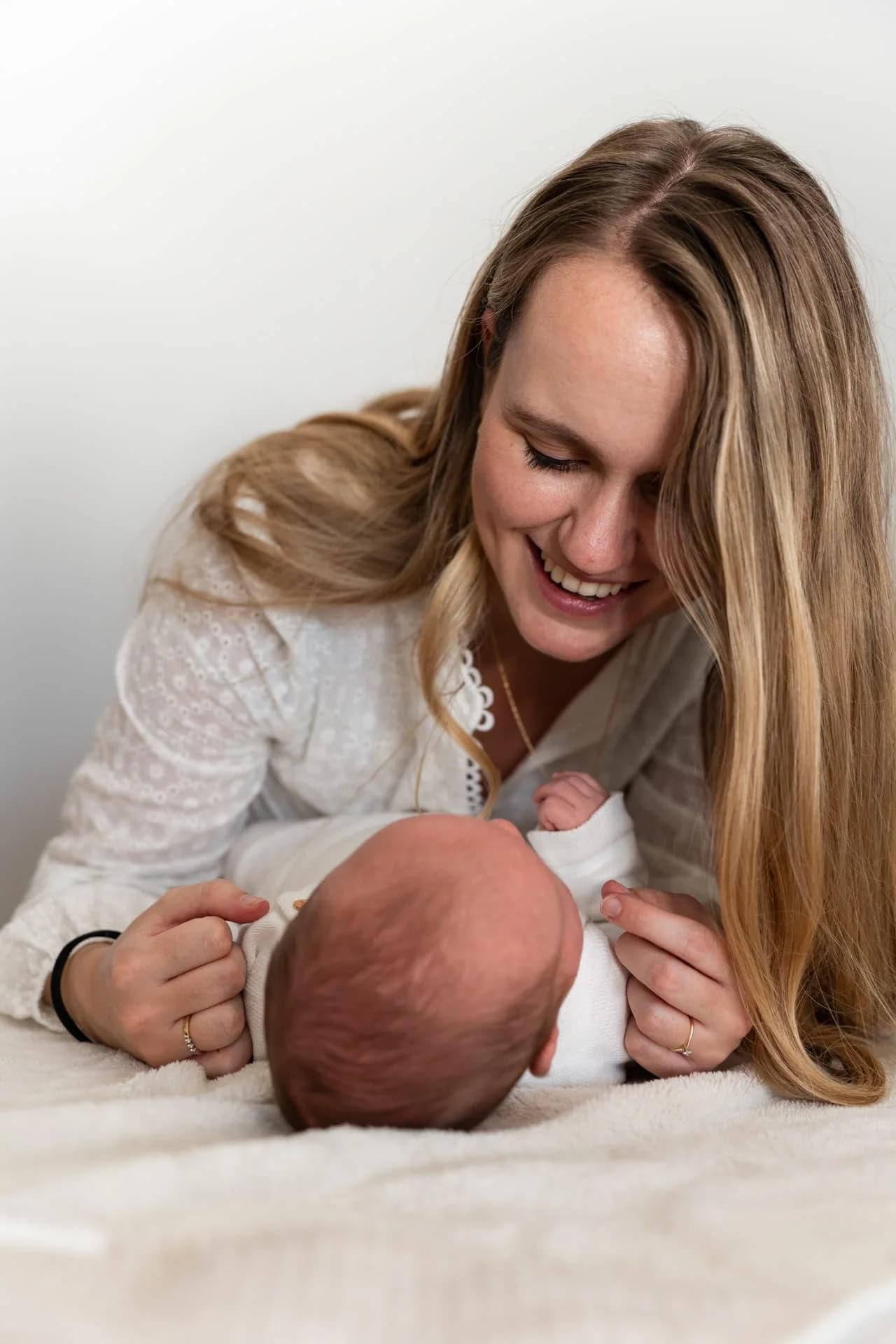 Moeder kijkt lachend naar baby Juda