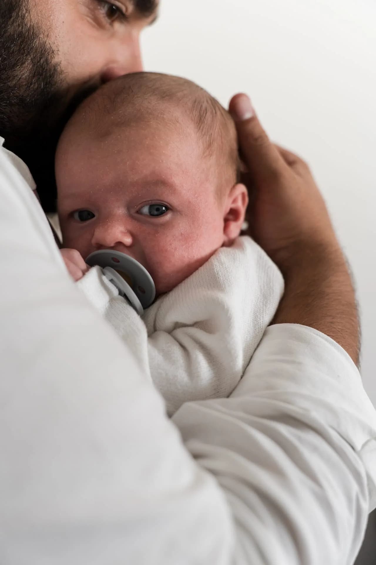 Baby Juda met een speen in de armen van zijn vader