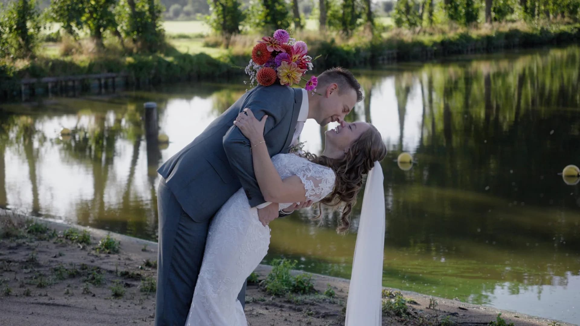 Elseline en Christiaan poseren bij het water op hun trouwdag