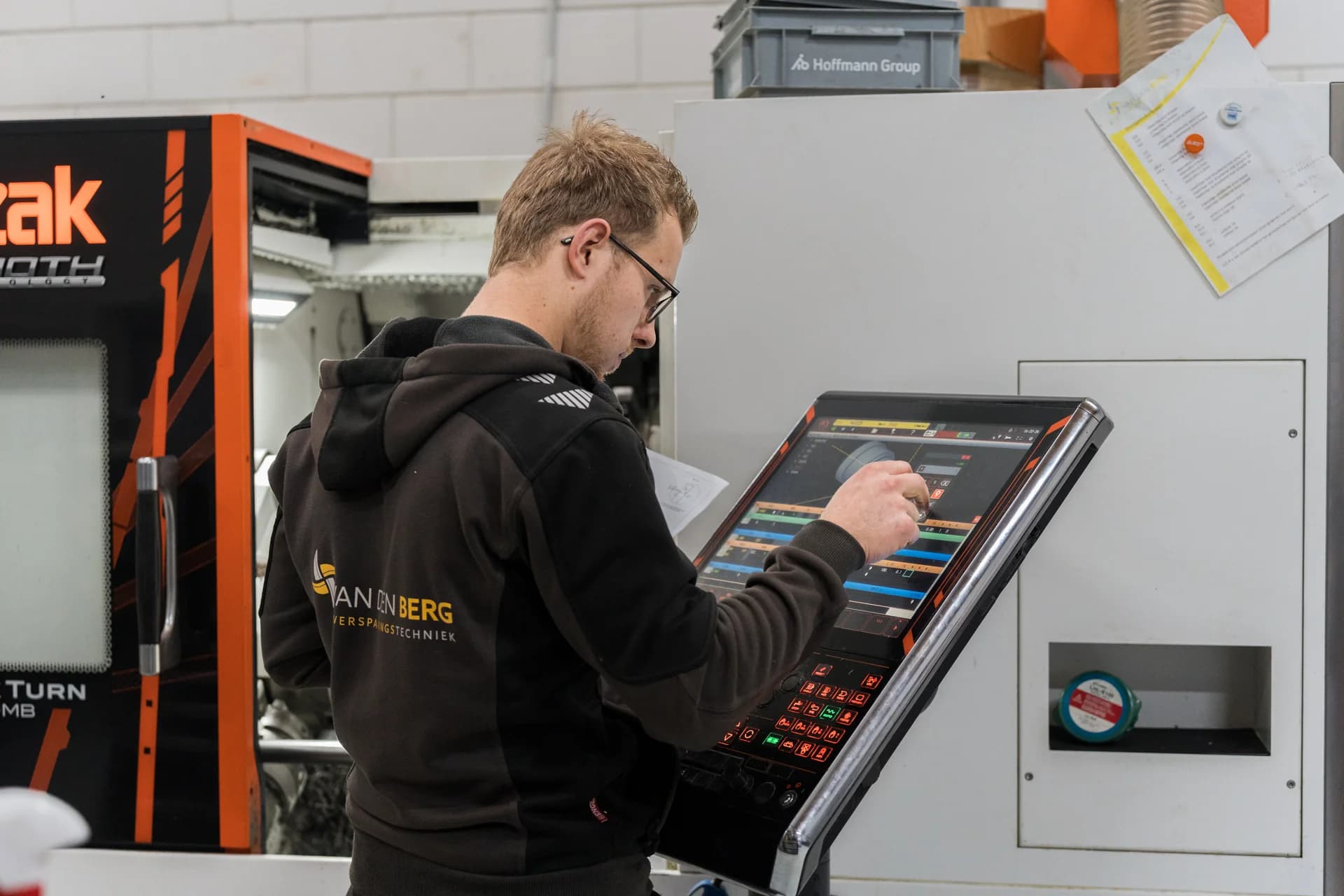 Medewerker bedient het touchscreen van een verspaningsmachine.