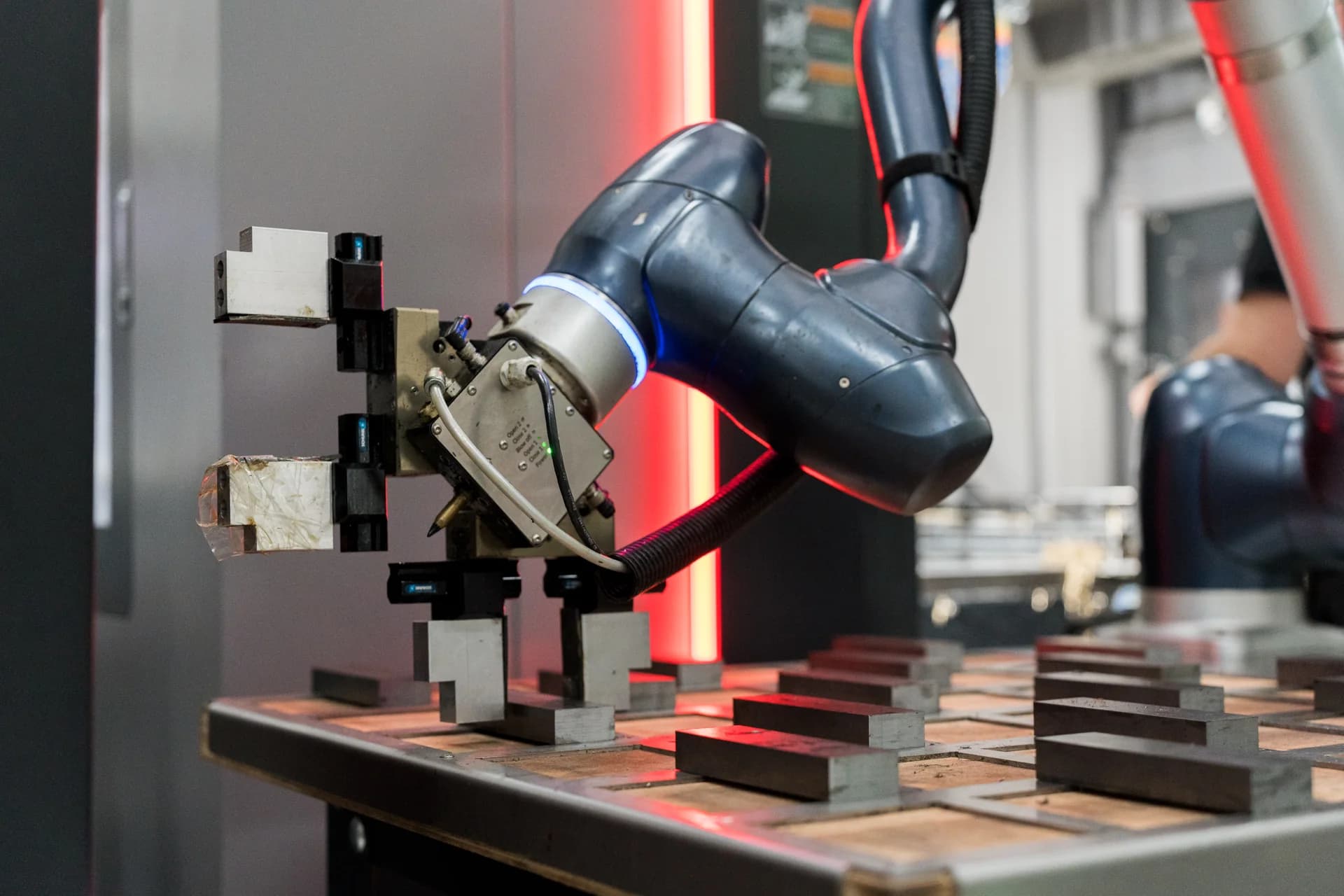 Robotarm met grijper bij een machine van Van den Berg Verspaningstechniek.