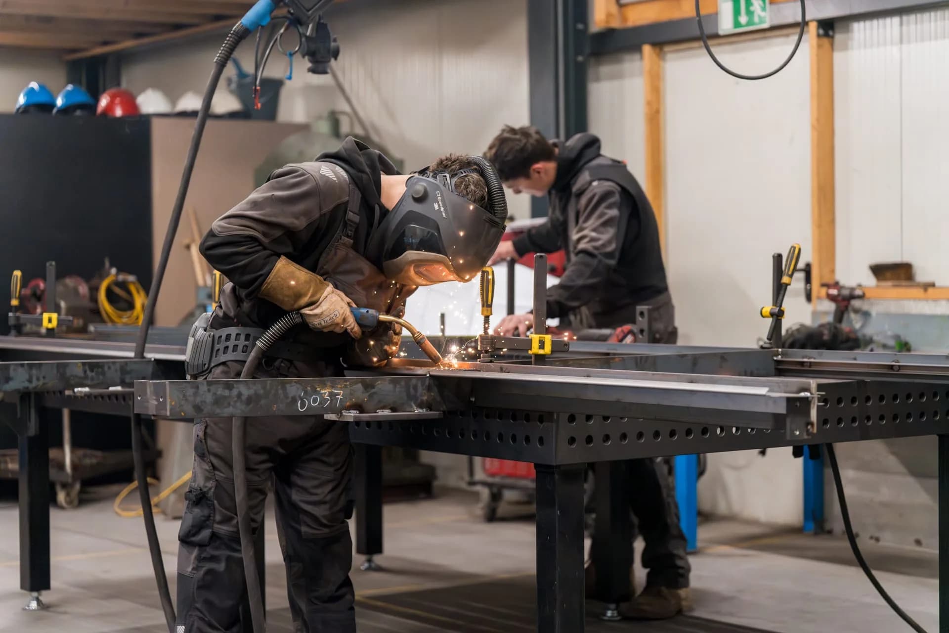 Medewerker van Versteeg & Flier last een metalen constructie