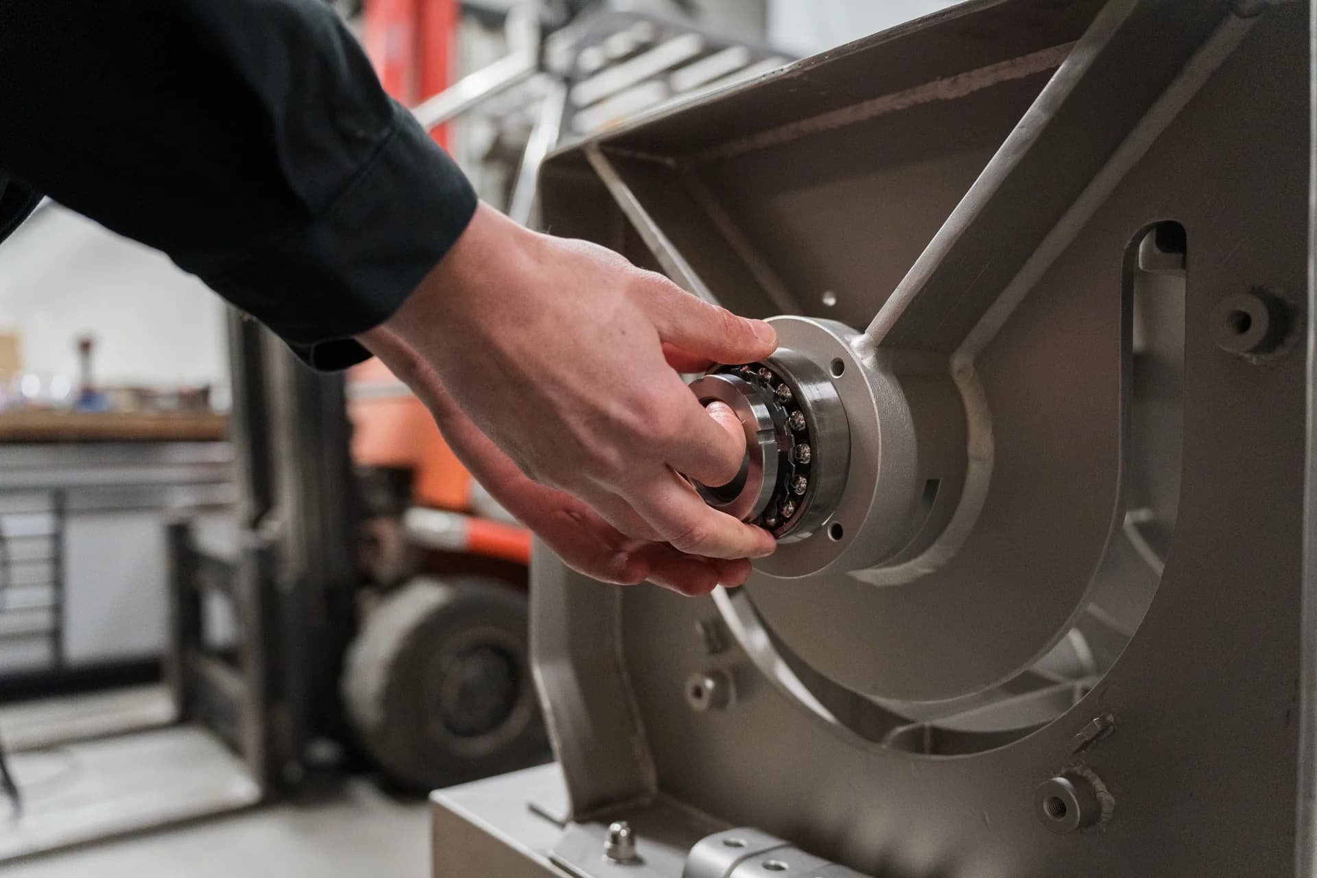 VMA Wekerom controleert een machineonderdeel in de werkplaats