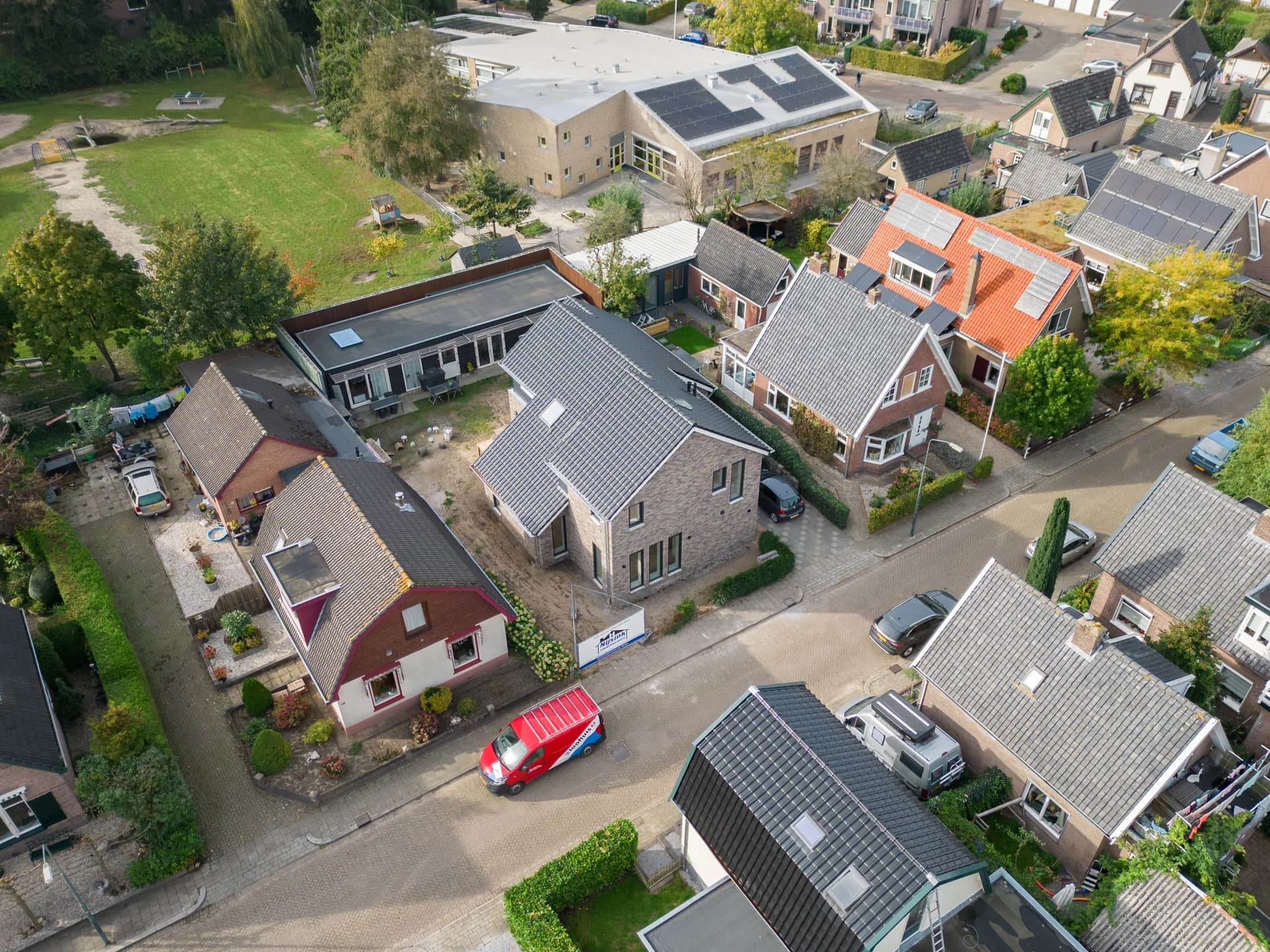 Luchtfoto van de gerenoveerde woning in een woonwijk.