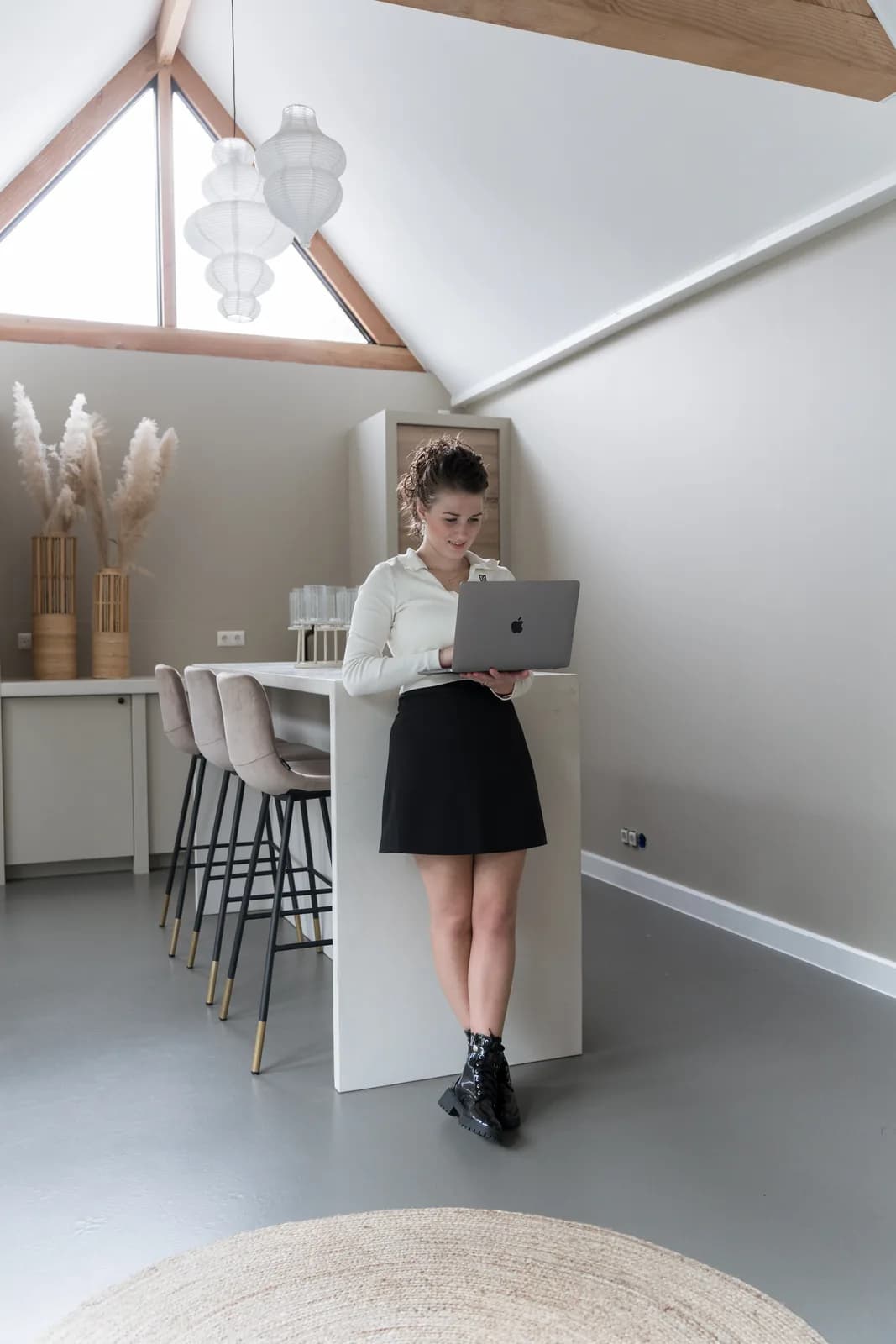 Joanne werkt staand op een laptop