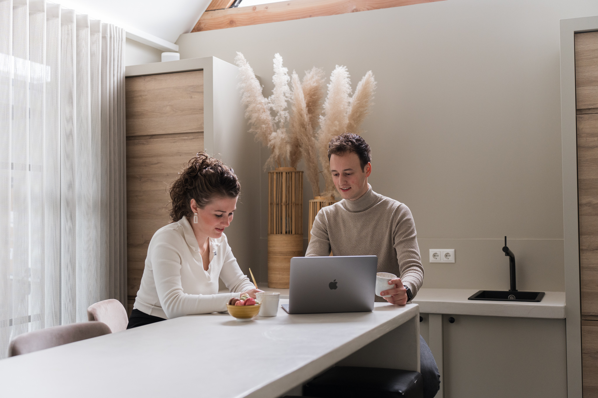 Niels en Joanne, de eigenaren van Visulions, overleggen met een laptop.